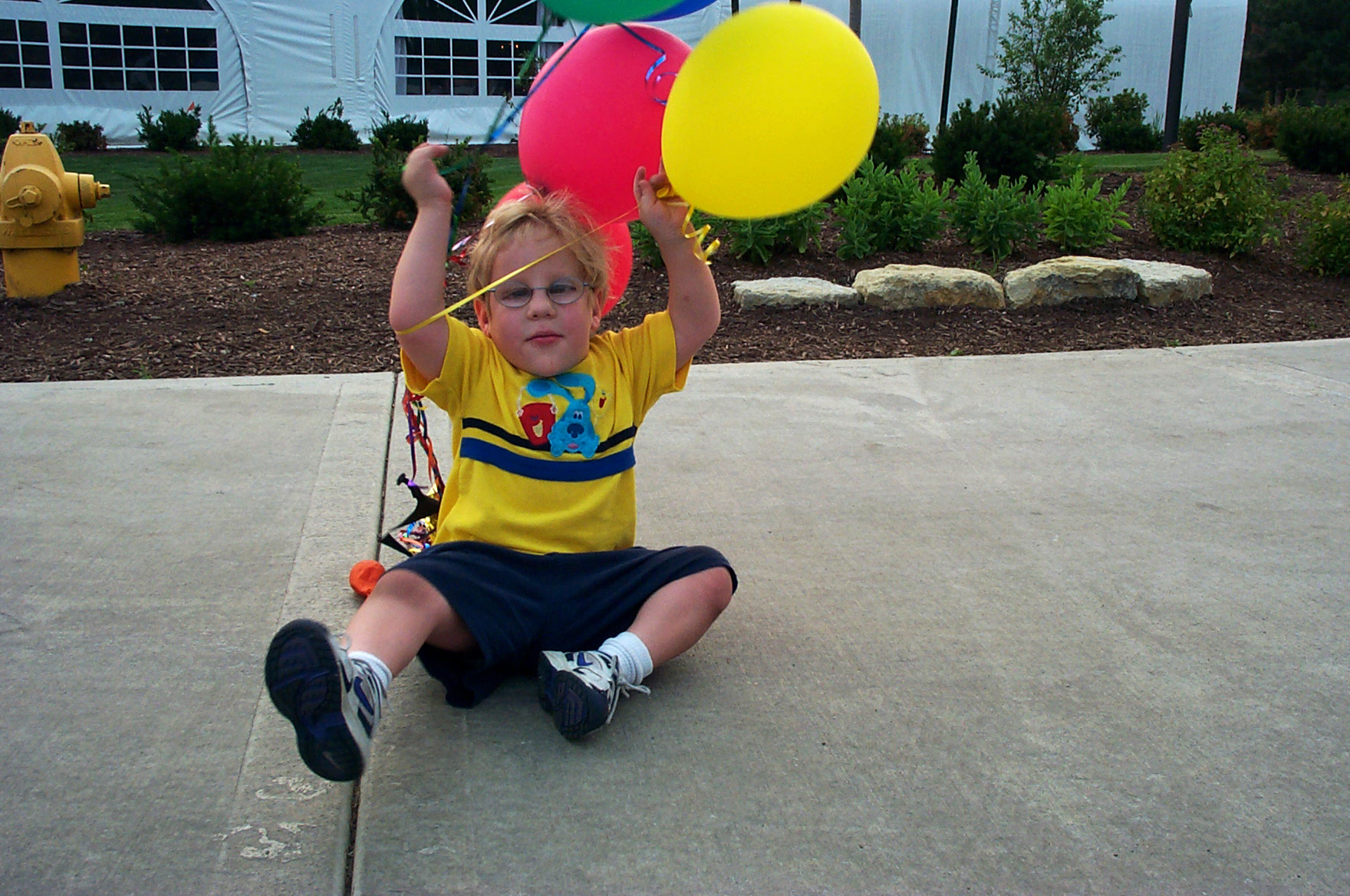 young boy with Lowe syndrome holding balloons